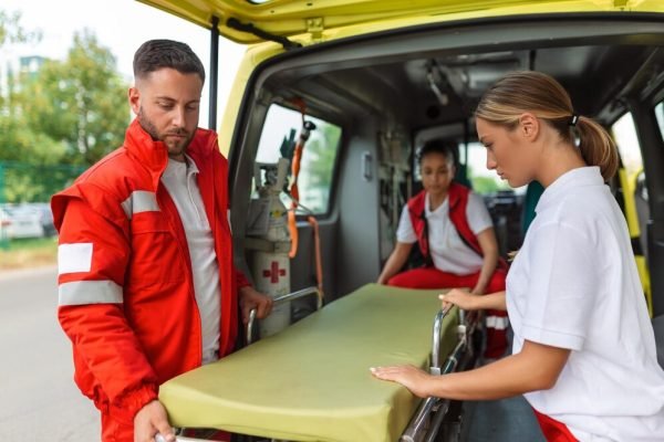 three-paramedics-taking-out-strecher-from-ambulance_657921-1469